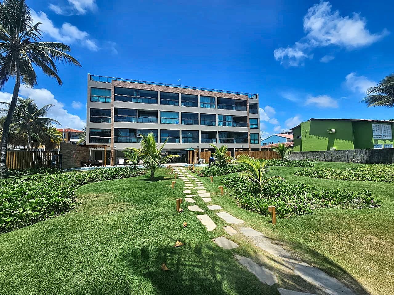 Fachada do Kauai Beach Residence em Tamandaré, vista do jardim com caminho de pedras