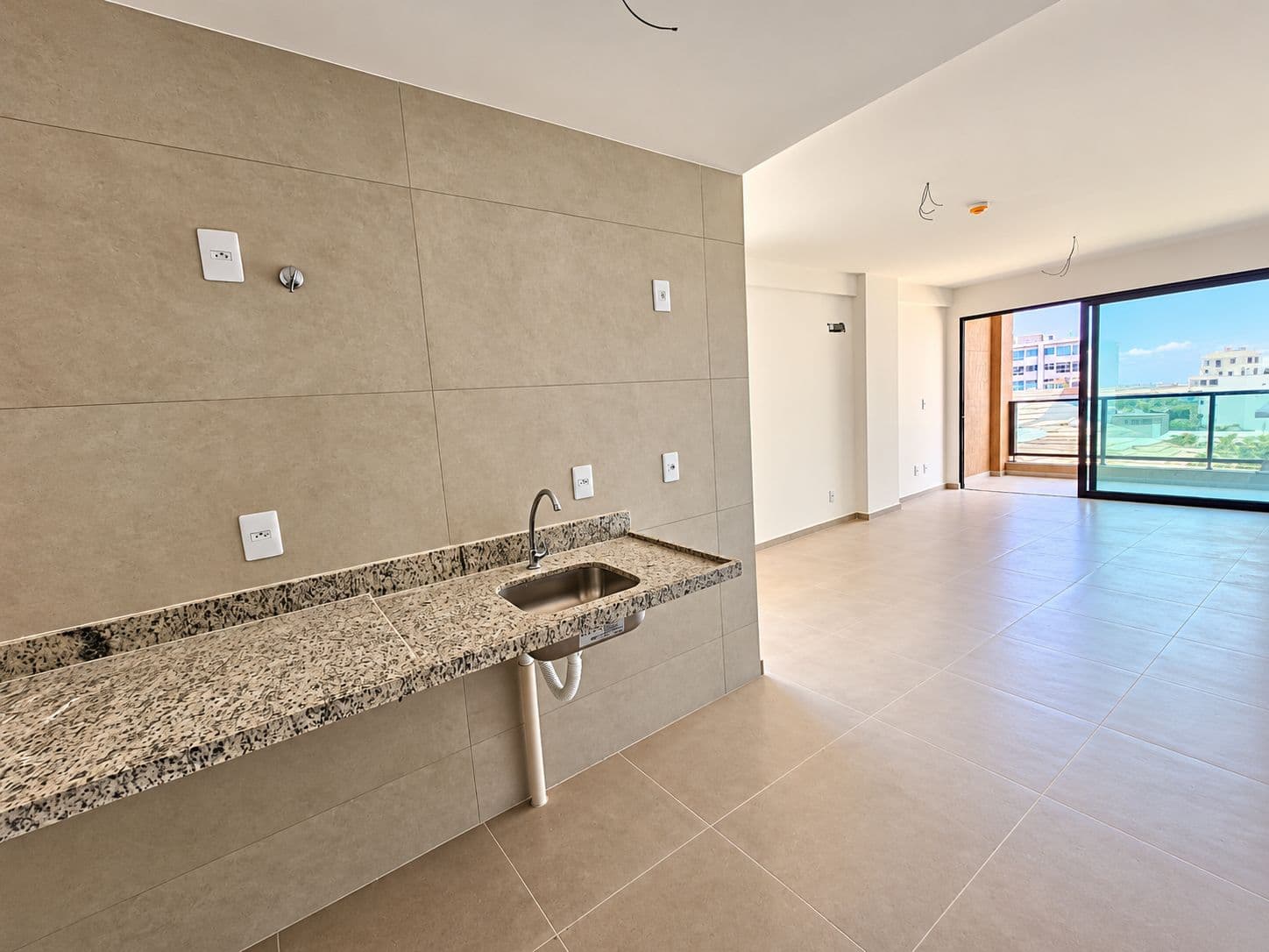 Sala com cozinha e varanda de um flat do Kauai Beach Residence