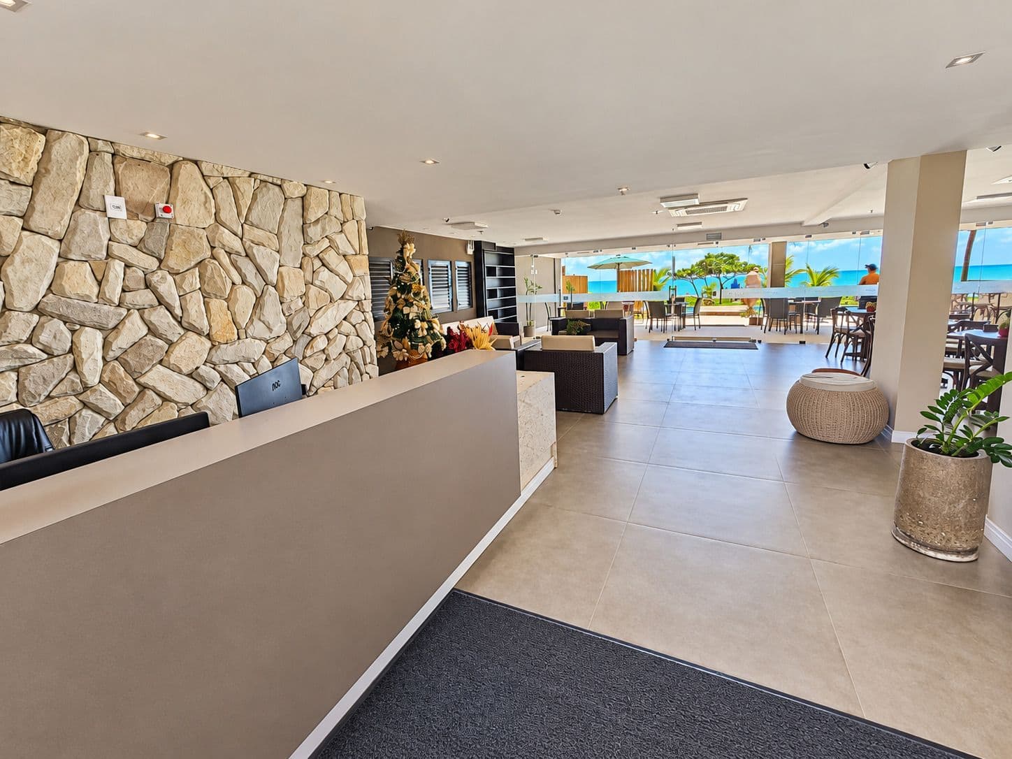Recepção do Kauai Beach Residence com parede de pedra e vista para o mar